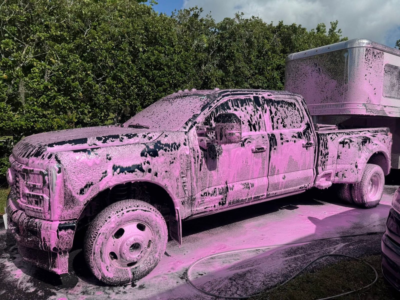 Ford Super Duty and trailer covered in foam cannon suds during a CamperKleen wash